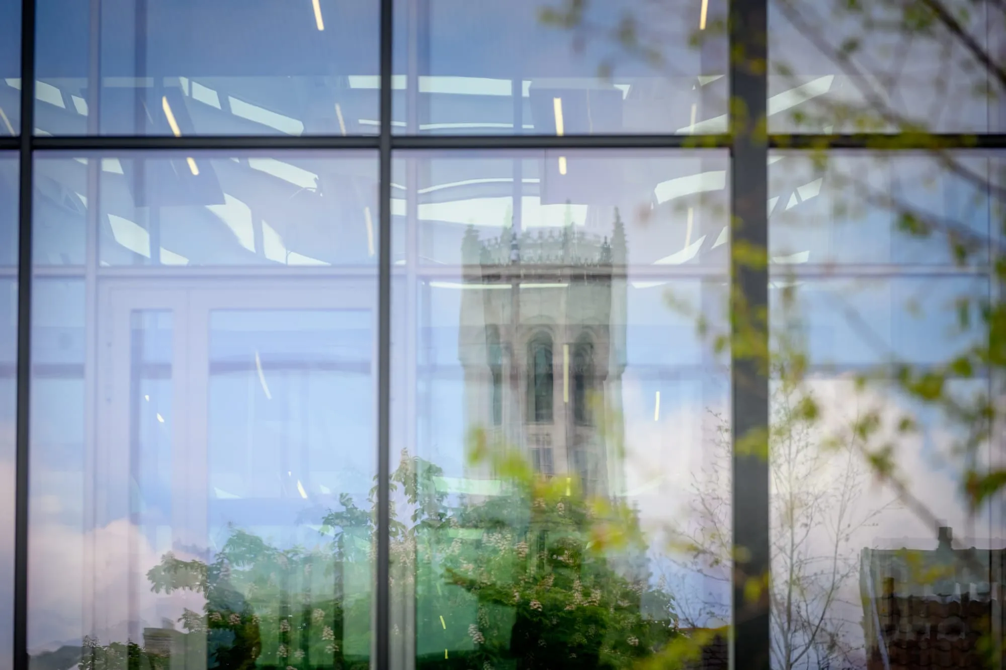 The Gothic tower of the Church of Our Lady reflected in a contemporary glass wall