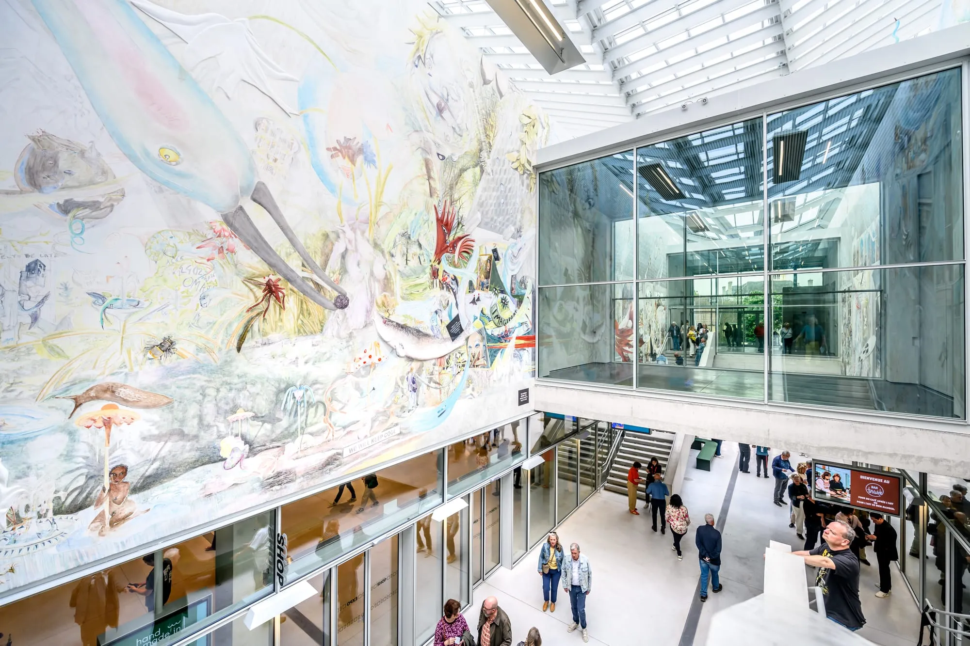 Atrium of a contemporary art museum with a monumental floor-to-ceiling mural