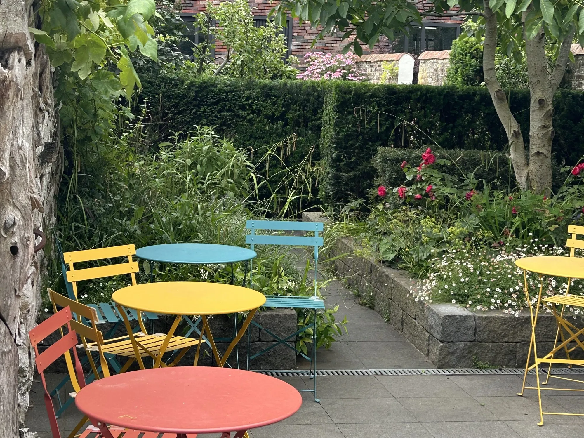 Colourful bistro chairs among the garden greenery