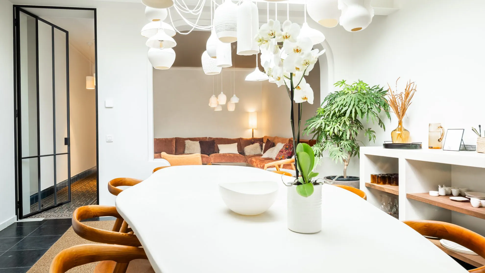The dining area with its long table and cascading porcelain pendant lights