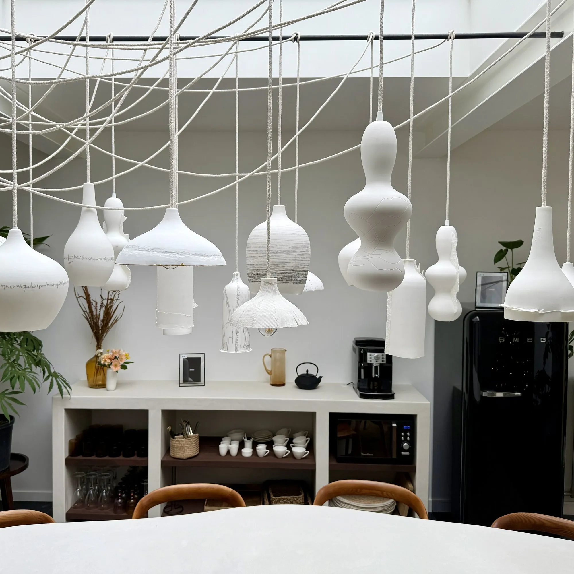 Handmade porcelain pendant lights above the dining table at 't Kleihuys